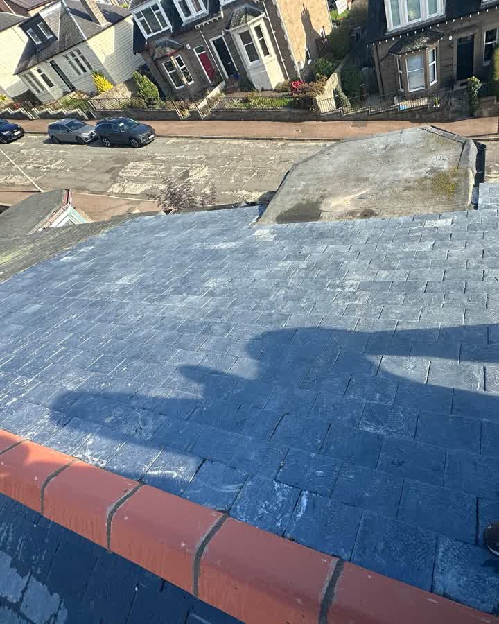 The same roof re-covered in new natural slate with a clean ridge line after the re-roof
